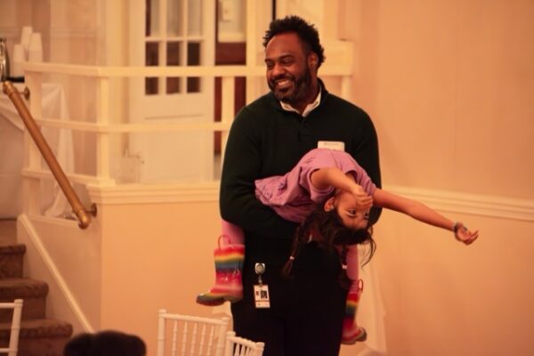 Step and Repeat candid photo of man interacting with daughter