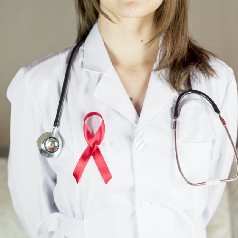 Destigmatizing Care for HIV and Infectious Disease Patients - HIV awareness ribbon on doctor