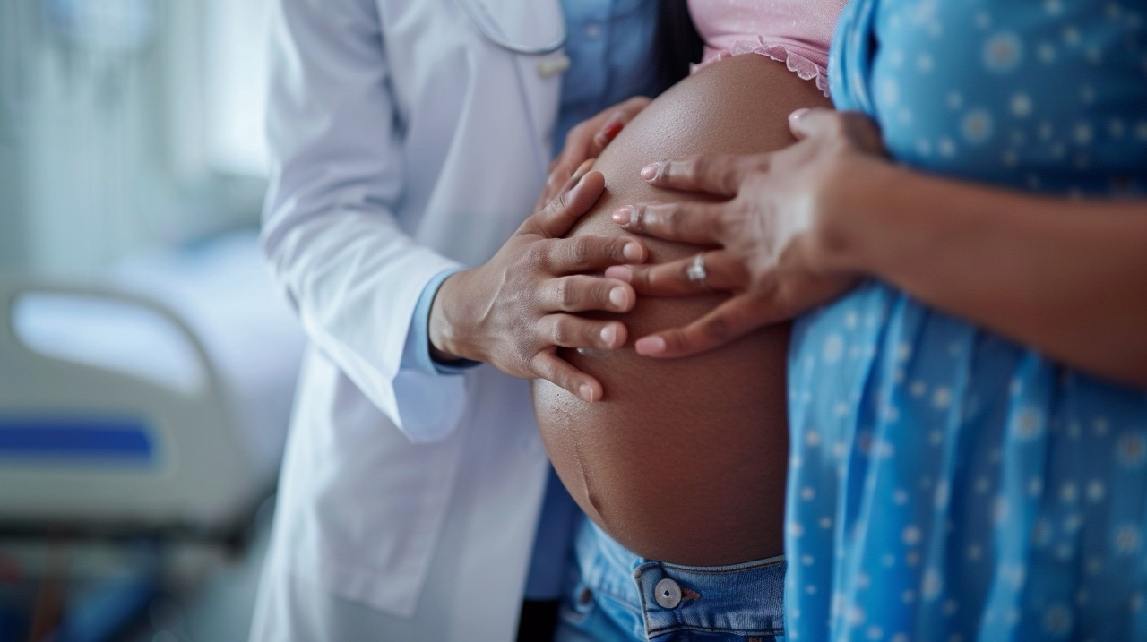 Lynn Community Health Center’s OB/GYN Services doctor with hand on pregnant belly