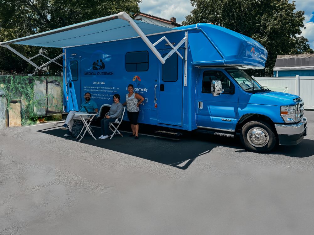Medical Outreach Program 3 LCHC's medical outreach van with people sitting under the awning.