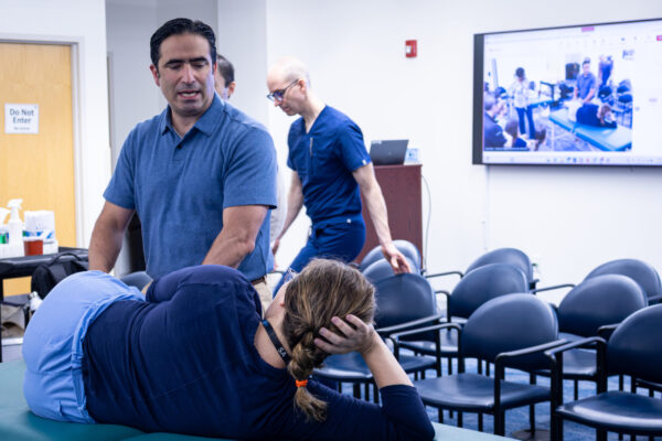 Doctor setting up for a demonstration with patient lying on table