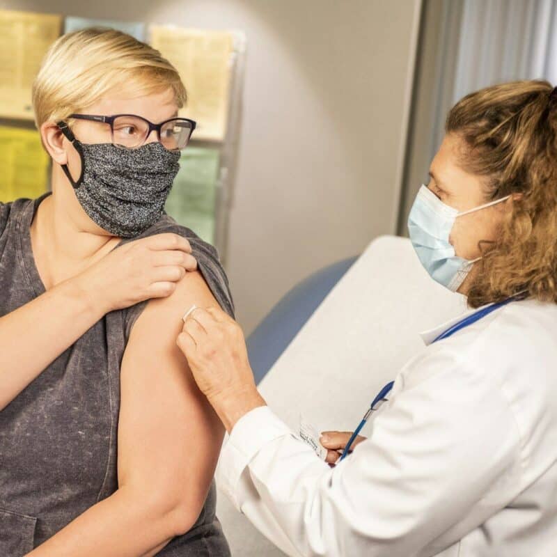 woman getting flu shot from a doctor.